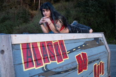 Nonbinary-traveler-LGBTQ-Alaska-laying-on-truck